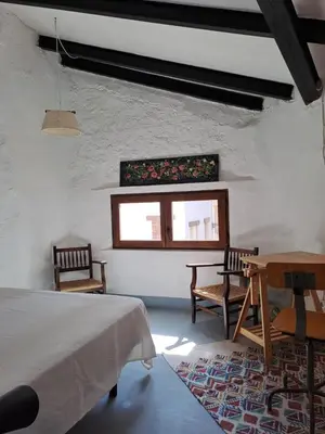 a bedroom with two chairs and a table and a window at El Cap de Pedra in Calles