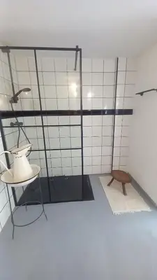 a bathroom with a shower with a sink and a table at El Cap de Pedra in Calles