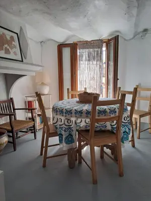 a dining room with a table and chairs and a window at El Cap de Pedra in Calles