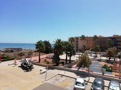 a parking lot with cars parked next to a beach at Primer piso de 2 habitaciones en unifamiliar frente al mar in El Brosquil