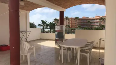 a patio with a table and chairs on a balcony at Primer piso de 2 habitaciones en unifamiliar frente al mar in El Brosquil