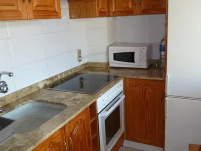 a kitchen with a sink and a microwave at Primer piso de 2 habitaciones en unifamiliar frente al mar in El Brosquil