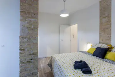 a bedroom with a bed and a brick wall at Apartment Ruzafa Tomasos in Valencia