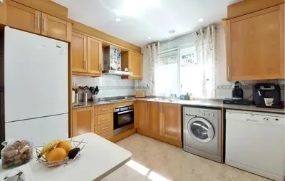 a kitchen with wooden cabinets and a white refrigerator at Awesome Home In Turis in Turís