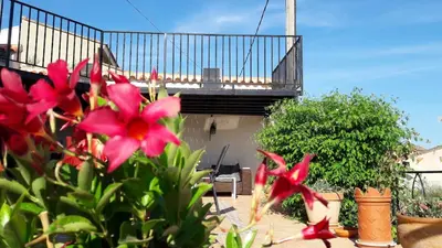 a garden with red flowers in front of a balcony at Quesa Tranquil Valencia in Quesa
