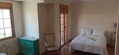 a bedroom with a bed and a chair and a mirror at Casa Paola in Buñol