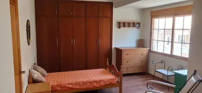 a bedroom with a bed and a cabinet and a window at Casa Paola in Buñol