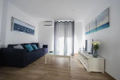 a living room with a blue couch and a tv at Invalencia - Leones flat Suite in Valencia