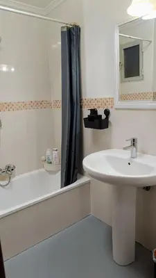 a white bathroom with a sink and a tub and a mirror at Disfruta en familia junto al mar in Playa Pobla de Farnals