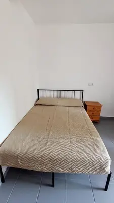 a large bed in a room with a bed frame at Disfruta en familia junto al mar in Playa Pobla de Farnals
