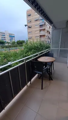 a balcony with a table and chairs on a building at Disfruta en familia junto al mar in Playa Pobla de Farnals