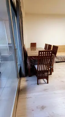 a dining room with a wooden table and chairs at Disfruta en familia junto al mar in Playa Pobla de Farnals