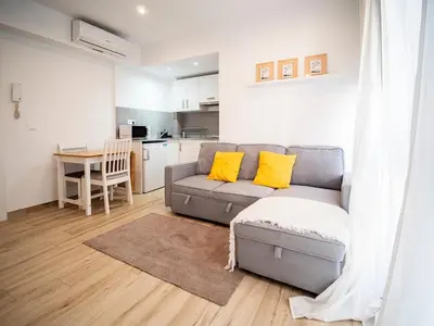 a living room with a gray couch with yellow pillows at Apartment Ruzafa Market 6C in Valencia