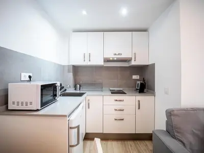 a small kitchen with white cabinets and a microwave at Apartment Ruzafa Market 6C in Valencia