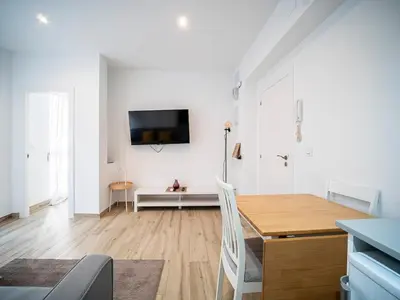 a living room with a table and a tv on a wall at Apartment Ruzafa Market 6C in Valencia