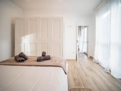 a white bedroom with a bed with two pillows on it at Apartment Ruzafa Market 6C in Valencia