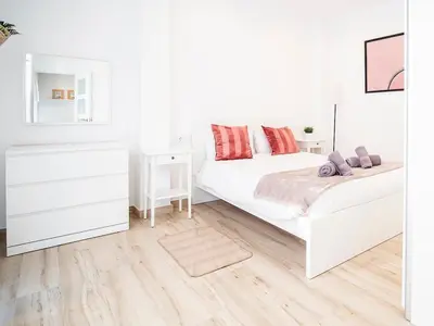 a white bedroom with two beds and a nightstand at Apartment Ruzafa Market 6C in Valencia