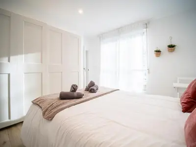a white bedroom with a large bed with towels on it at Apartment Ruzafa Market 6C in Valencia