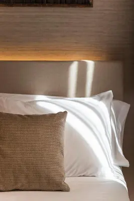 a bed with white pillows and a wooden headboard at Blanq Gran vía in Valencia