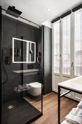 a bathroom with a toilet and a glass shower at Blanq Gran vía in Valencia