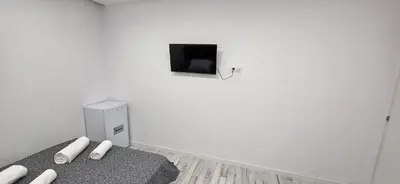 a white room with a bed and a tv on the wall at Mi Huésped 130 Valencia, Aeropuerto Manises in Manises