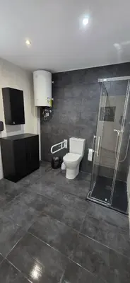 a bathroom with a toilet and a glass shower at Mi Huésped 130 Valencia, Aeropuerto Manises in Manises