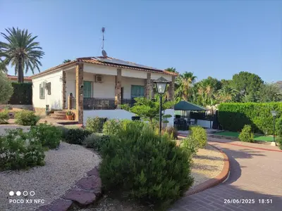 a house with a porch and a courtyard with plants at Chalet en el parque natural de la Calderona in Náquera