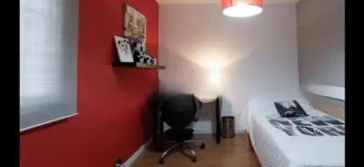 a bedroom with a bed and a red wall at Torrent Veda Chalet in Torrent