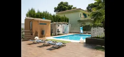 a house with a swimming pool with chairs in front of it at Torrent Veda Chalet in Torrent