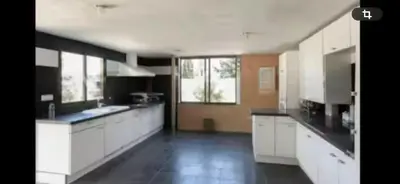 a large kitchen with white cabinets and black counter tops at Torrent Veda Chalet in Torrent