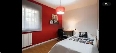 a bedroom with a red wall with a bed and a desk at Torrent Veda Chalet in Torrent