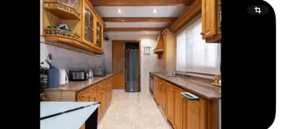 a kitchen with wooden cabinets and a counter top at Torrent Veda Chalet in Torrent