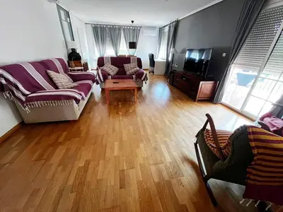 a living room with a purple couch and a wooden floor at Casa Mallaeta in Puebla de Vallbona