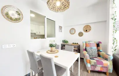 a dining room with a white table and a chair at Nice Apartment In Puebla De Farnals in Puebla de Farnals