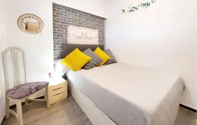 a small bedroom with a bed and a chair at Nice Apartment In Puebla De Farnals in Puebla de Farnals