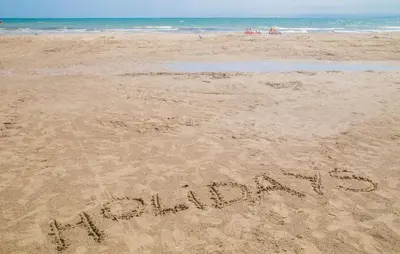 a sign written in the sand on a beach at Nice Apartment In Puebla De Farnals in Puebla de Farnals