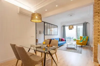 a living room with a table and a blue couch at Apartment with terrace in Extramurs in Valencia