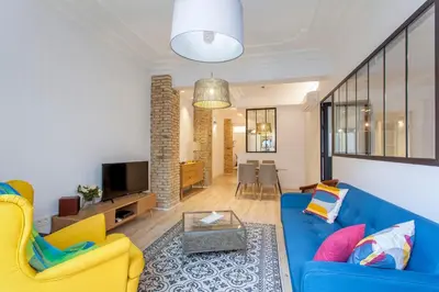 a living room with a blue couch and yellow chairs at Apartment with terrace in Extramurs in Valencia