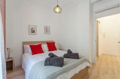 a bedroom with a large white bed with red pillows at Apartment with terrace in Extramurs in Valencia