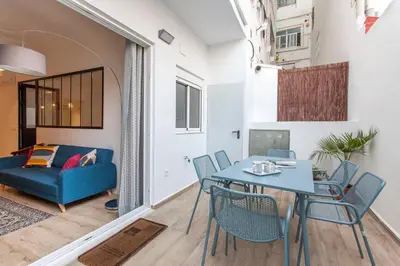 a living room with a table and chairs and a couch at Apartment with terrace in Extramurs in Valencia