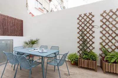 a table and chairs in a room with plants at Apartment with terrace in Extramurs in Valencia