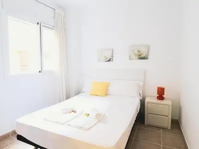 a white bed in a room with a window at Spectacular views of the sea and the lighthouse in Canet de Berenguer