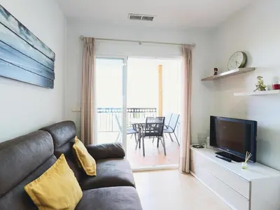 a living room with a couch and a television at Spectacular views of the sea and the lighthouse in Canet de Berenguer
