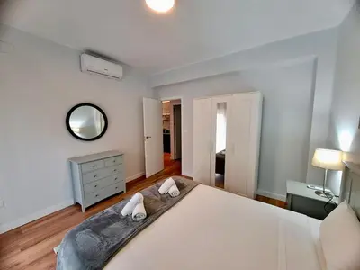 a bedroom with a large white bed and a mirror at Amazing bright and recently remodeled apartment in Valencia