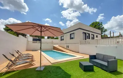 a patio with an umbrella and chairs and a pool at Amazing Home In Turís in Turís