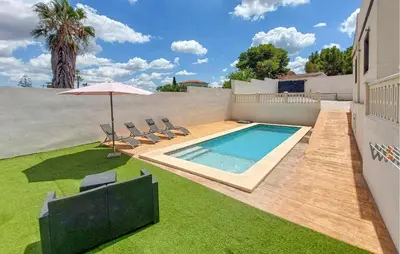 a swimming pool with chairs and an umbrella in a yard at Amazing Home In Turís in Turís