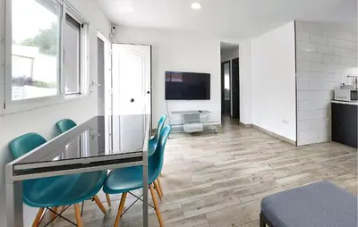 a dining room with a glass table and blue chairs at Amazing Home In Turís in Turís