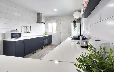 a white kitchen with a sink and a microwave at Amazing Home In Turís in Turís