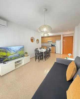 a living room with a couch and a tv and a table at UIM Mediterraneo Alpuente Wifi in Puerto de Sagunto