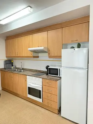 a kitchen with wooden cabinets and a white refrigerator at UIM Mediterraneo Alpuente Wifi in Puerto de Sagunto